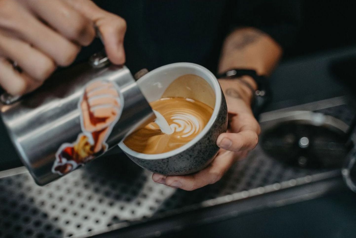Barista schenkt latte art in een café
